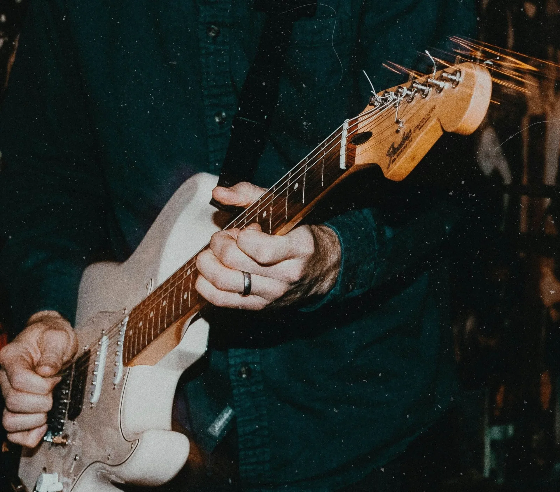 Vue rapprochée d'un homme qui joue de la guitare.